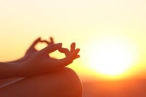 36434395 - back light of a woman hands exercising yoga at sunset with a warmth background